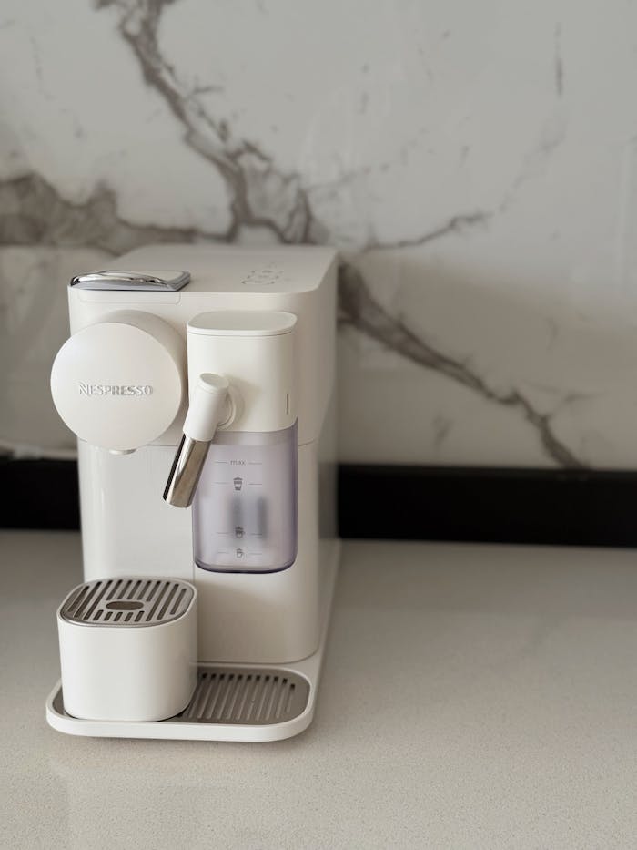 A sleek white espresso machine on a marble counter, perfect for coffee lovers.